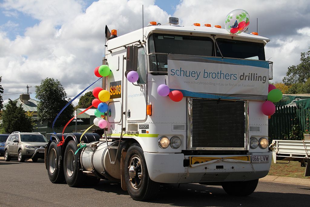 White semi-truck decorated with balloons and a banner reading 