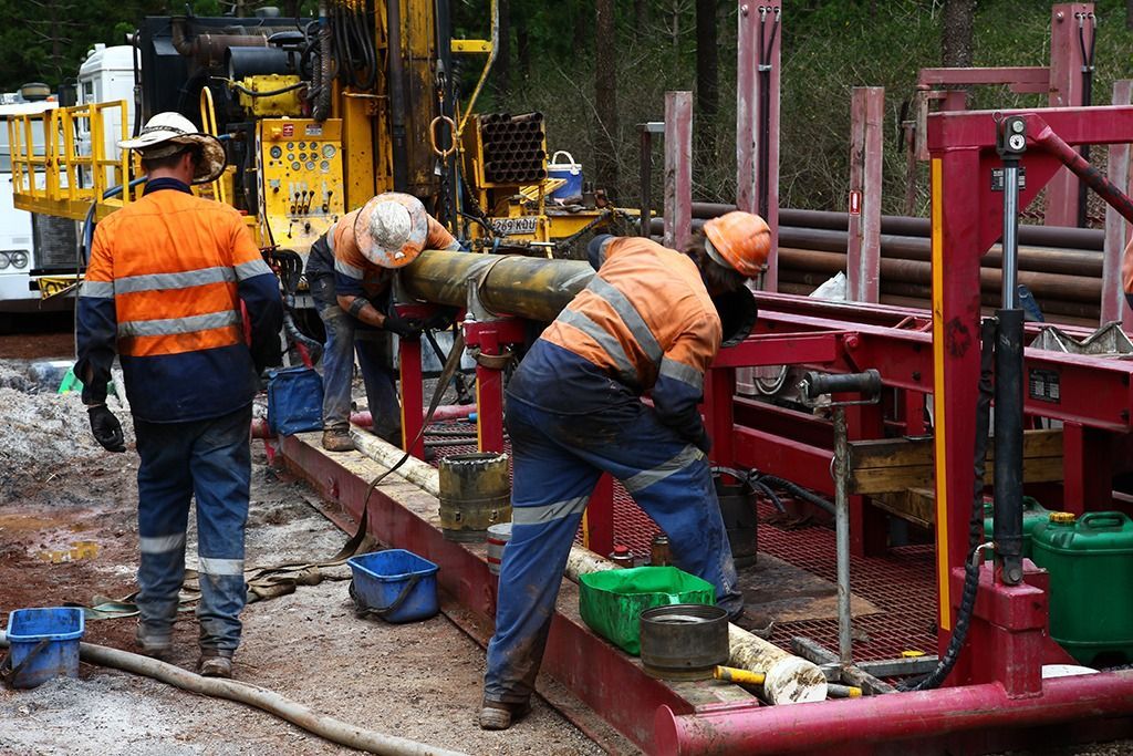 A group of trucks are parked on top of a dirt hill.