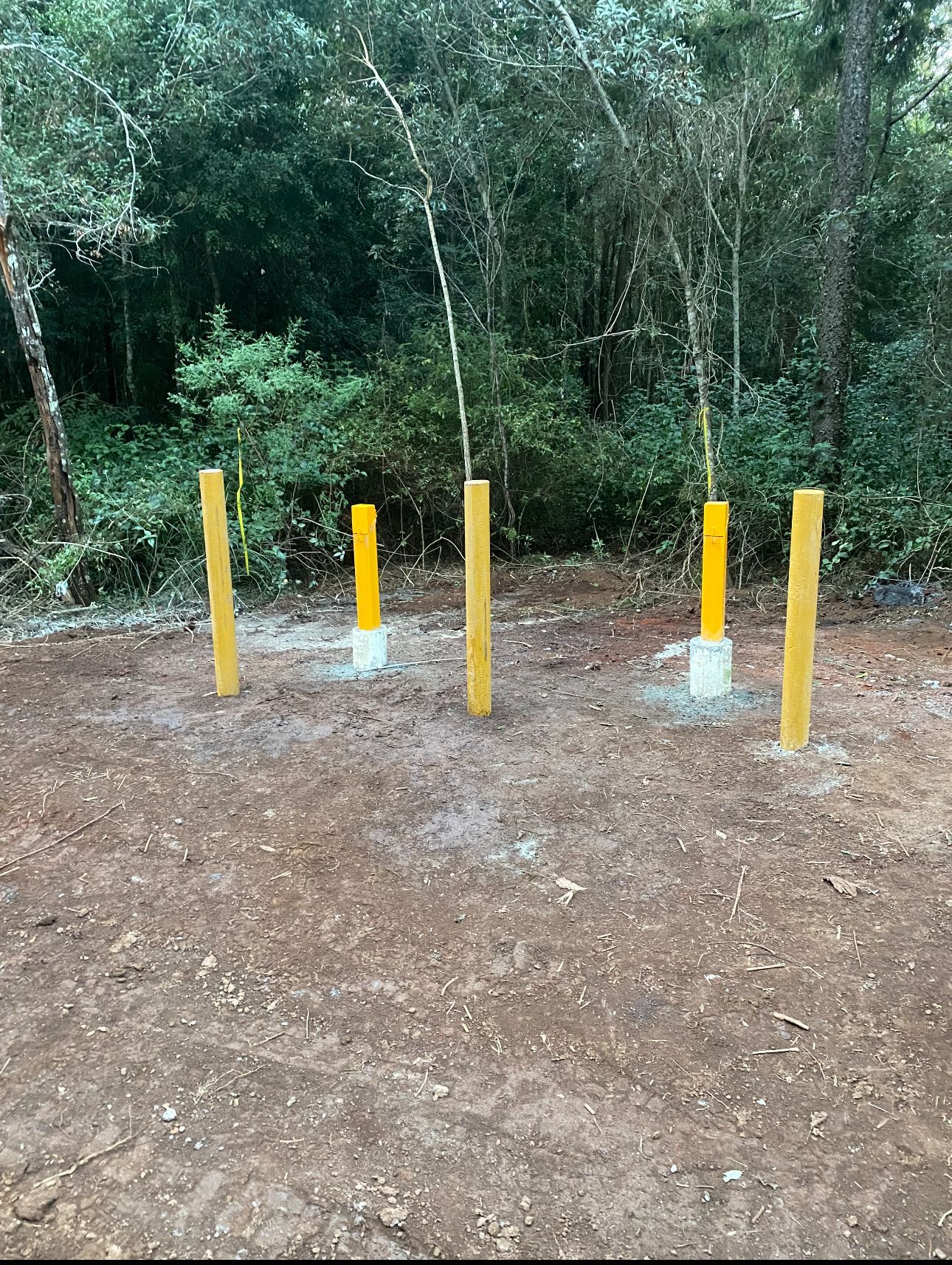 Two men wearing hard hats and safety vests are working on a construction site.