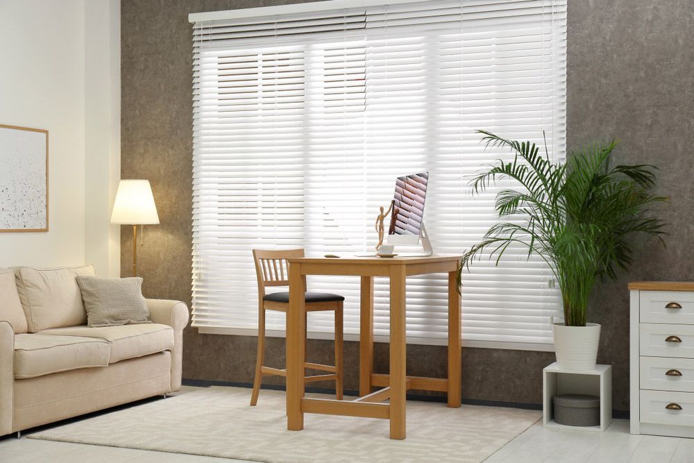 Comfortable Workplace Near Window Blinds In Room — Wholesale Window Coverings in Lake Macquarie, NSW