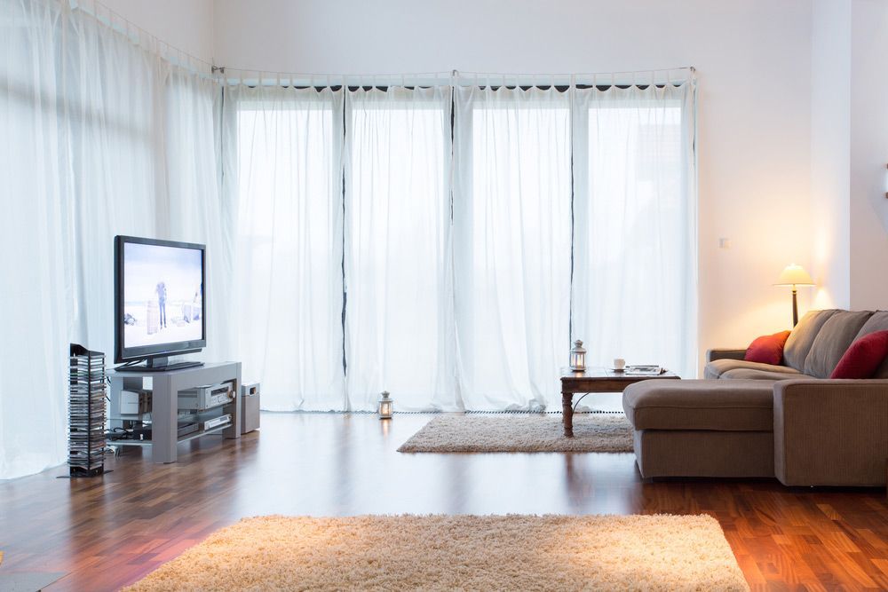 Bright Living Room With Big Windows With Curtains — Wholesale Window Coverings in Maitland, NSW