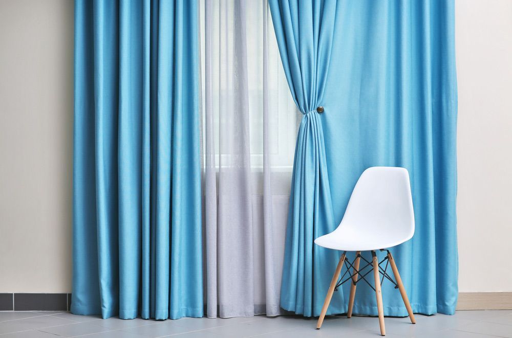Chair And Room Window With White And Blue Curtains  — Luxury Veri Shades in Cardiff, NSW