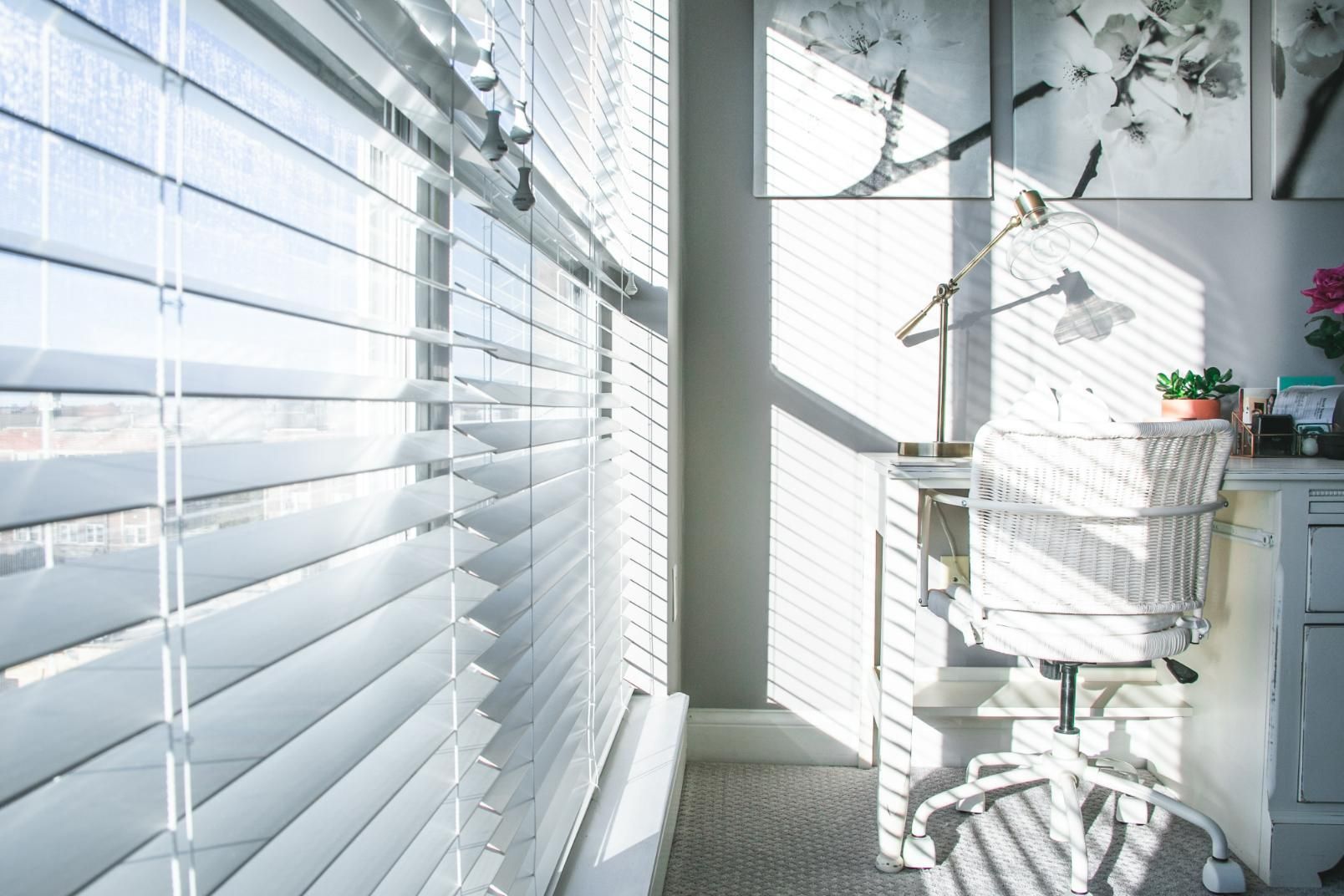 A White Chair Sits in Front of a Window With Blinds — Window Coverings in Cardiff, NSW