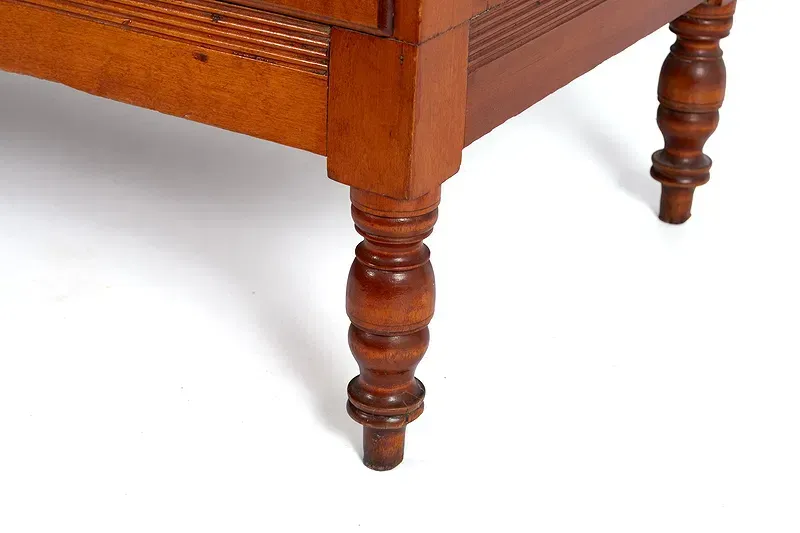 A close up of a wooden table leg on a white background