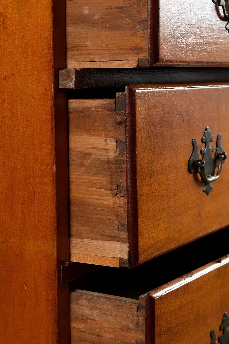 A close up of a wooden dresser with the drawers open.