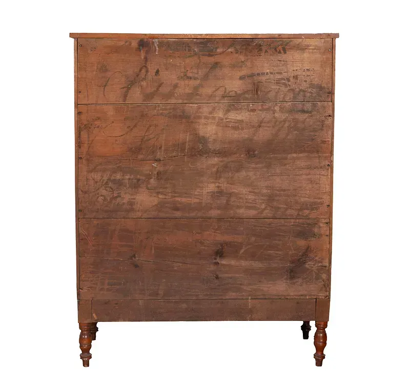 The back of a wooden dresser with a white background.