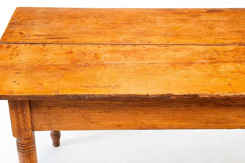 A wooden table is sitting on a white surface.