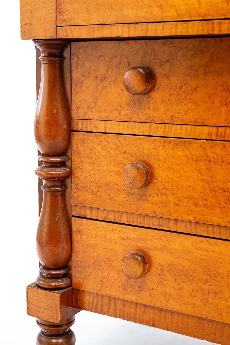 A close up of a wooden dresser with three drawers