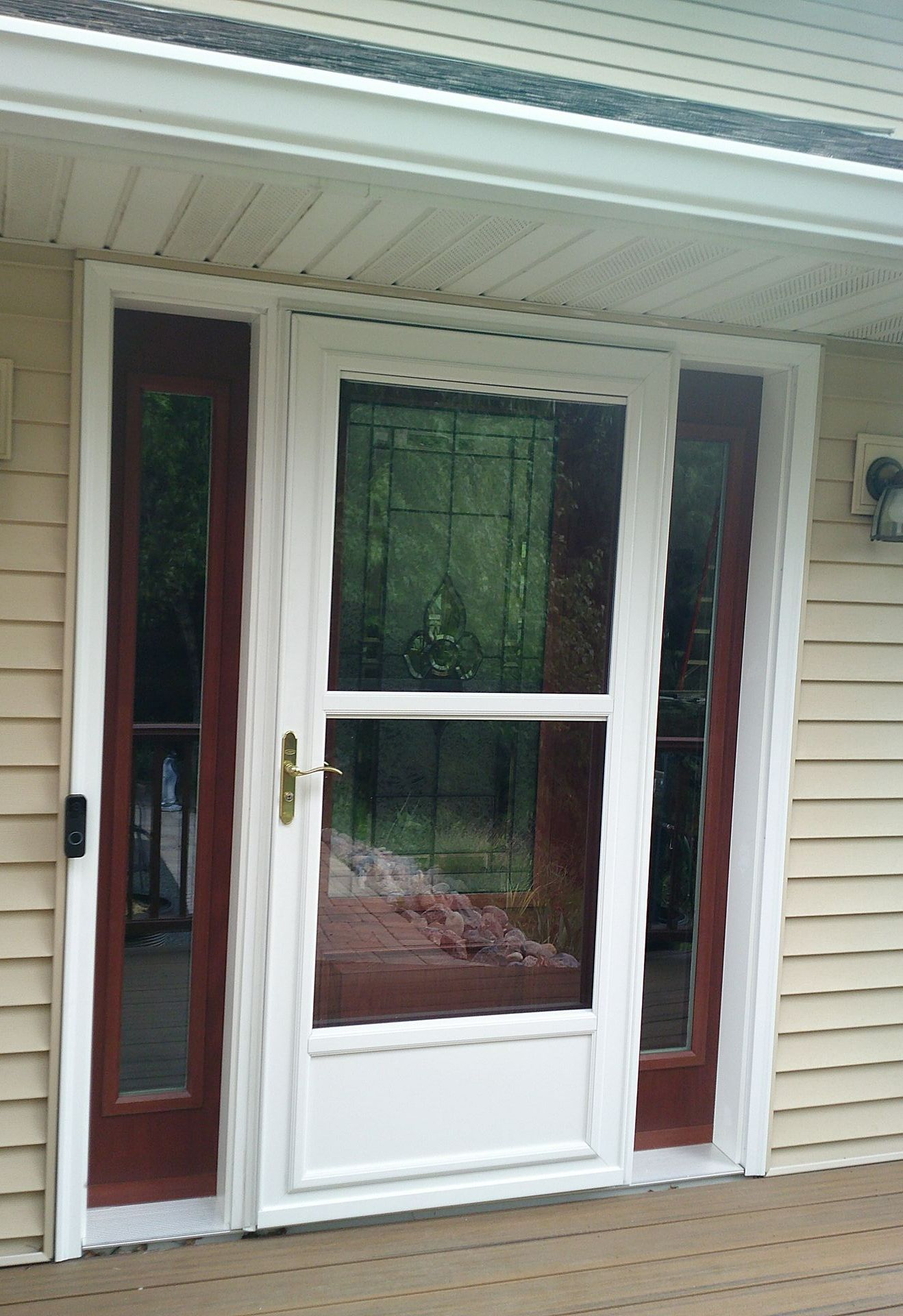 A white door with red trim is on the side of a house