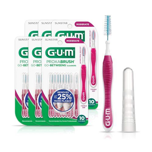 A person is holding a pink and white interdental brush