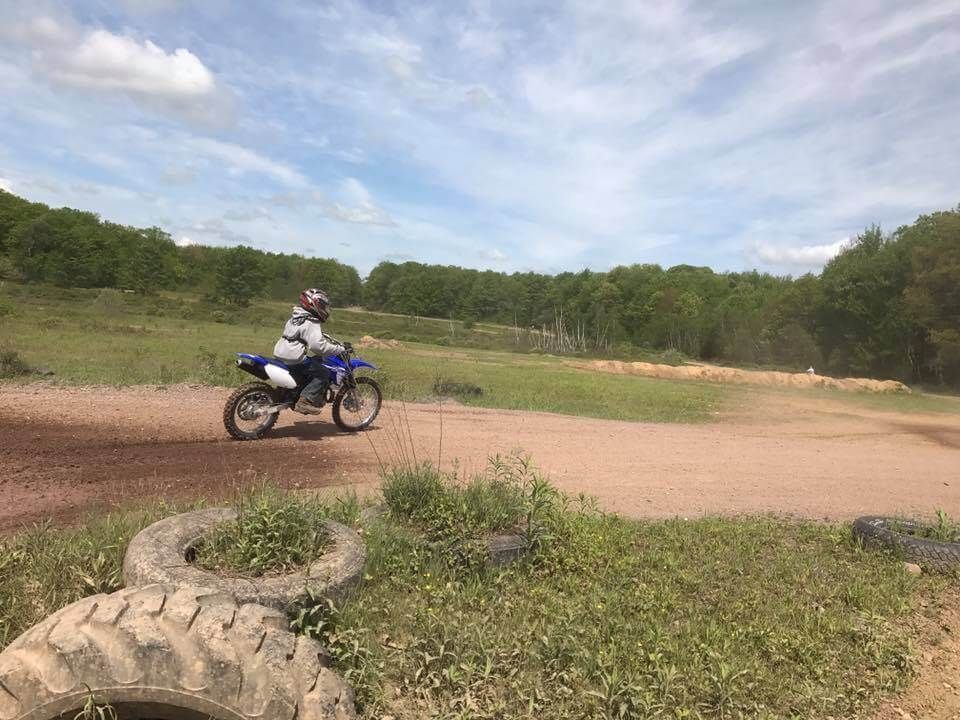 A person is riding a dirt bike on a dirt road.