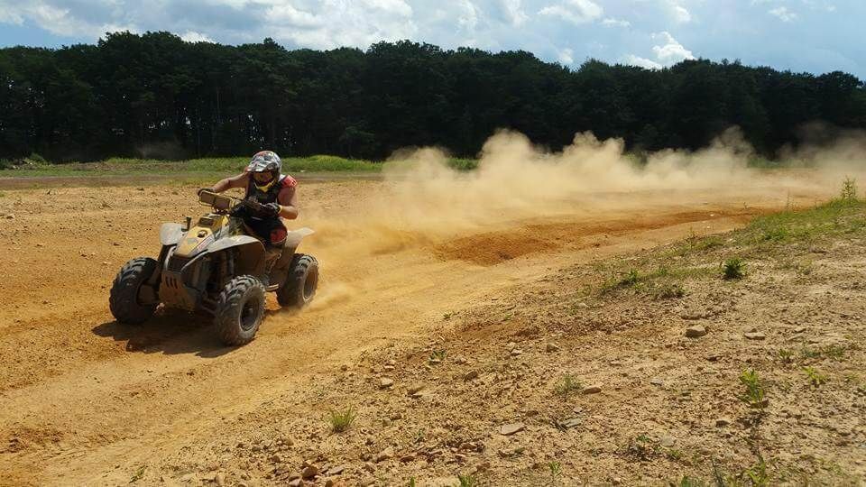 A person is riding an atv on a dirt road.