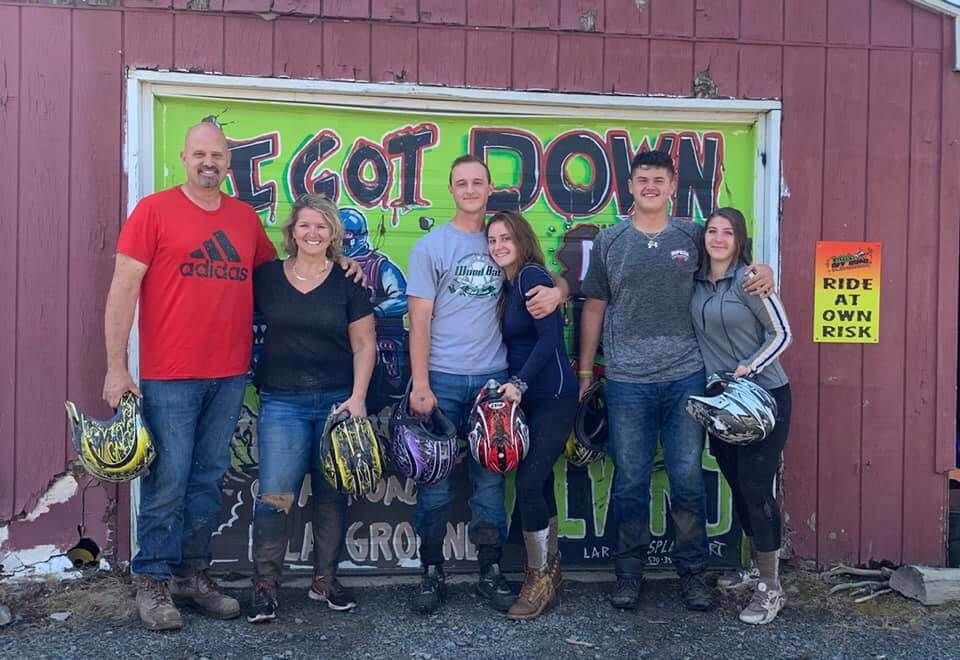 A group of people are posing for a picture in front of a sign that says `` i got down ''.