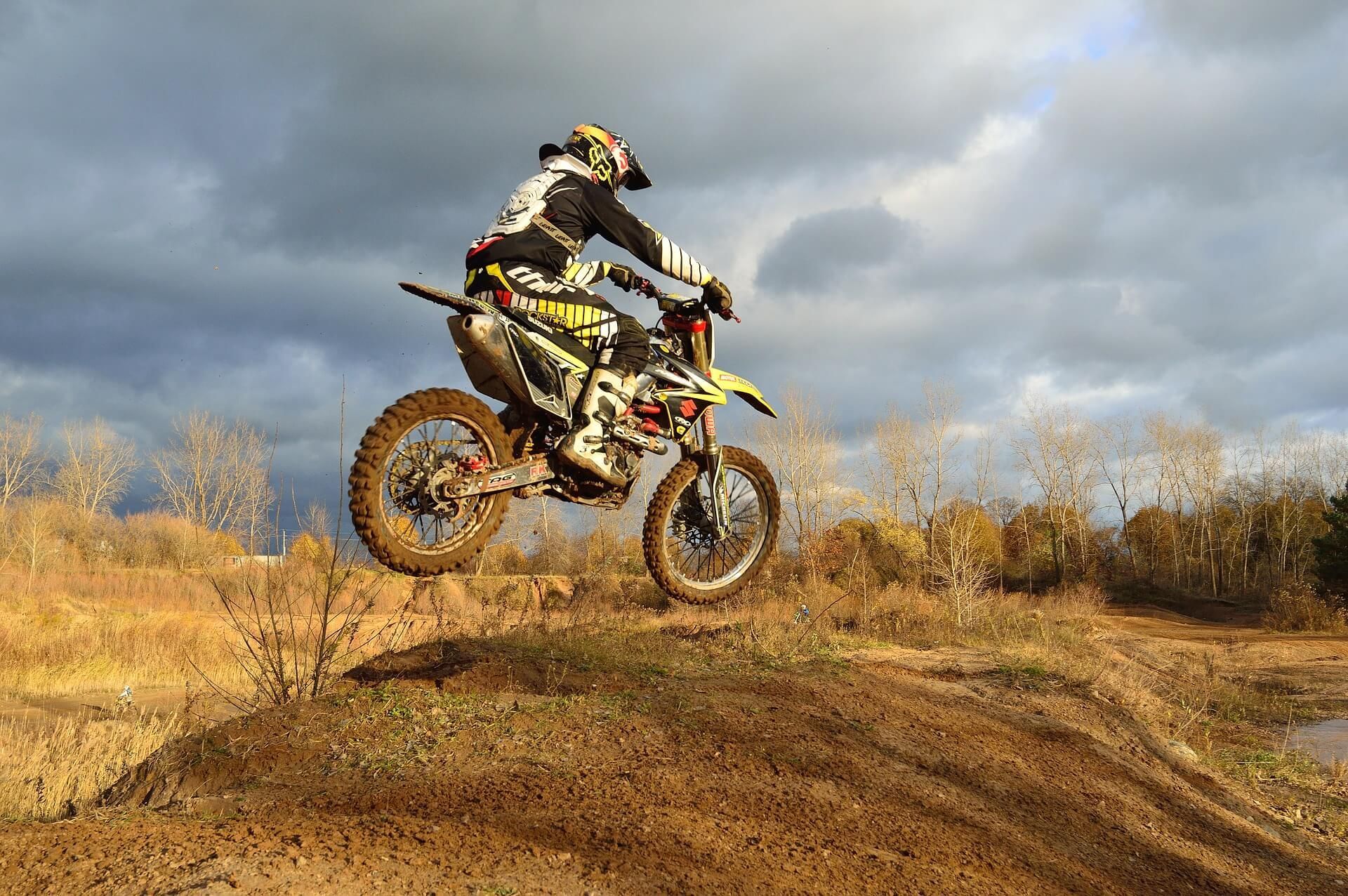 A person is riding a dirt bike on a dirt track.