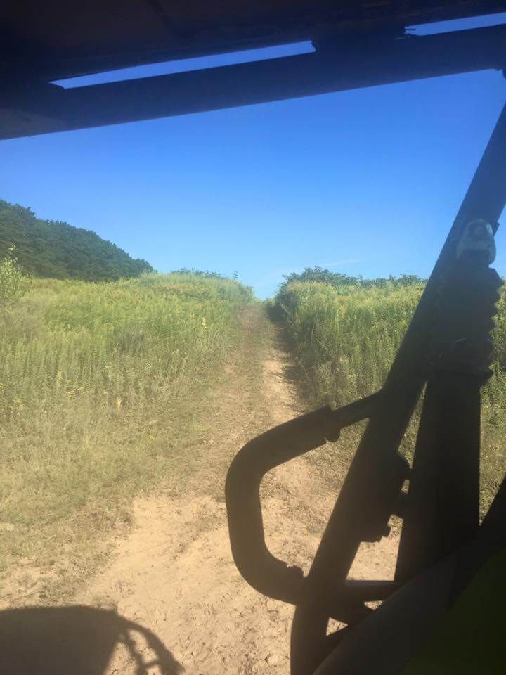 A person is riding a dirt bike down a dirt road.