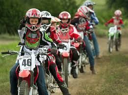 A group of people are riding dirt bikes on a dirt road.