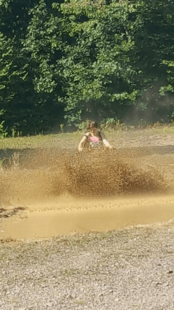 A person is riding a dirt bike on a dirt road.