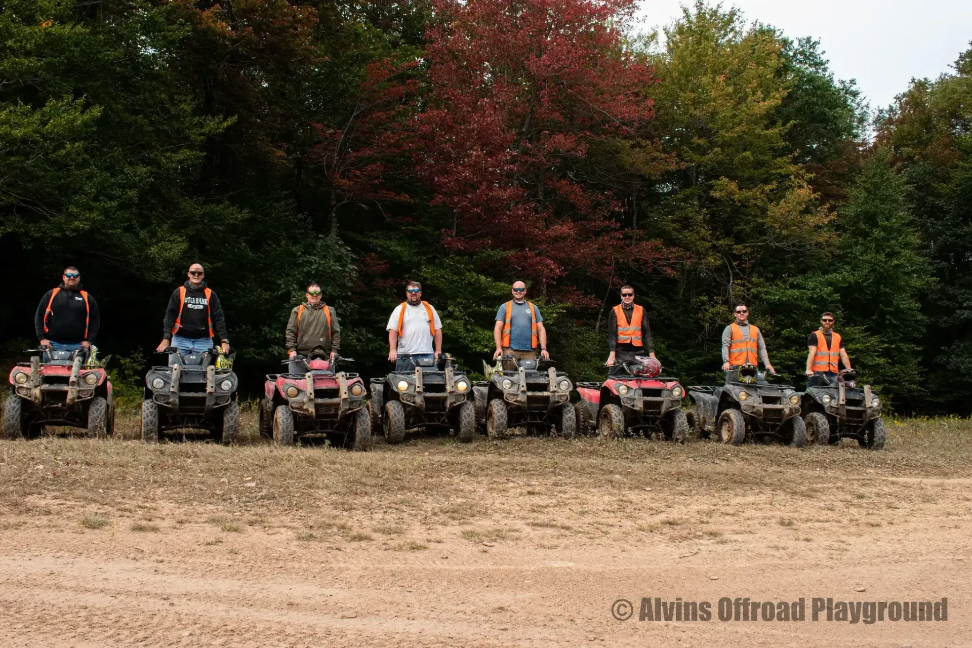 A group of people are riding atvs in a field.