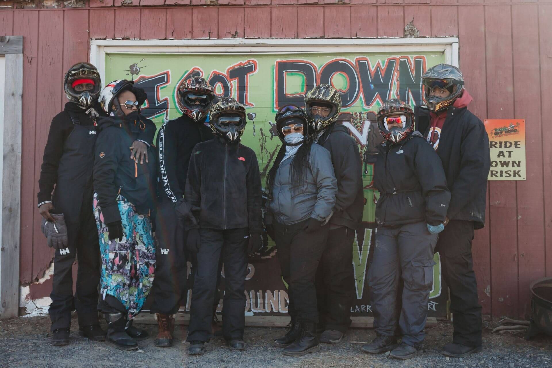 A group of people standing in front of a sign that says get down