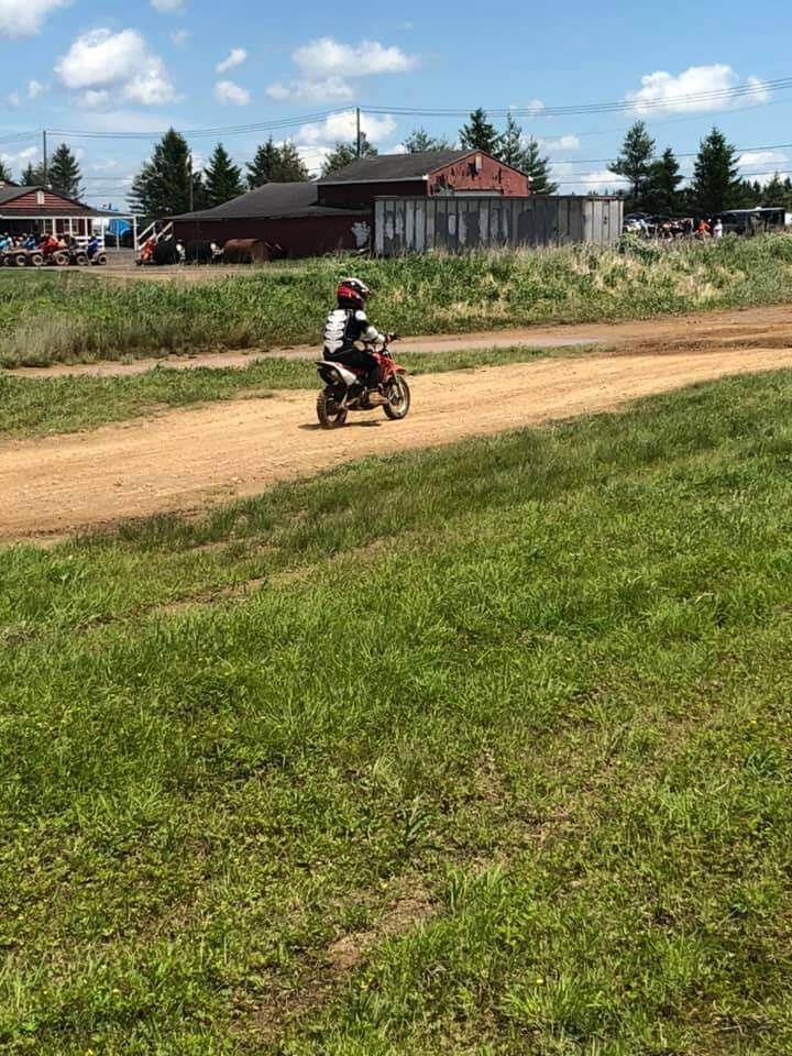 A person is riding a dirt bike on a dirt road.