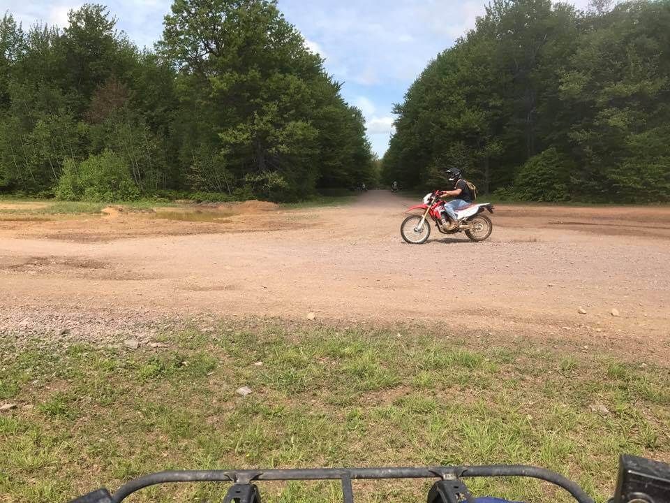 A person is riding a dirt bike on a dirt road.