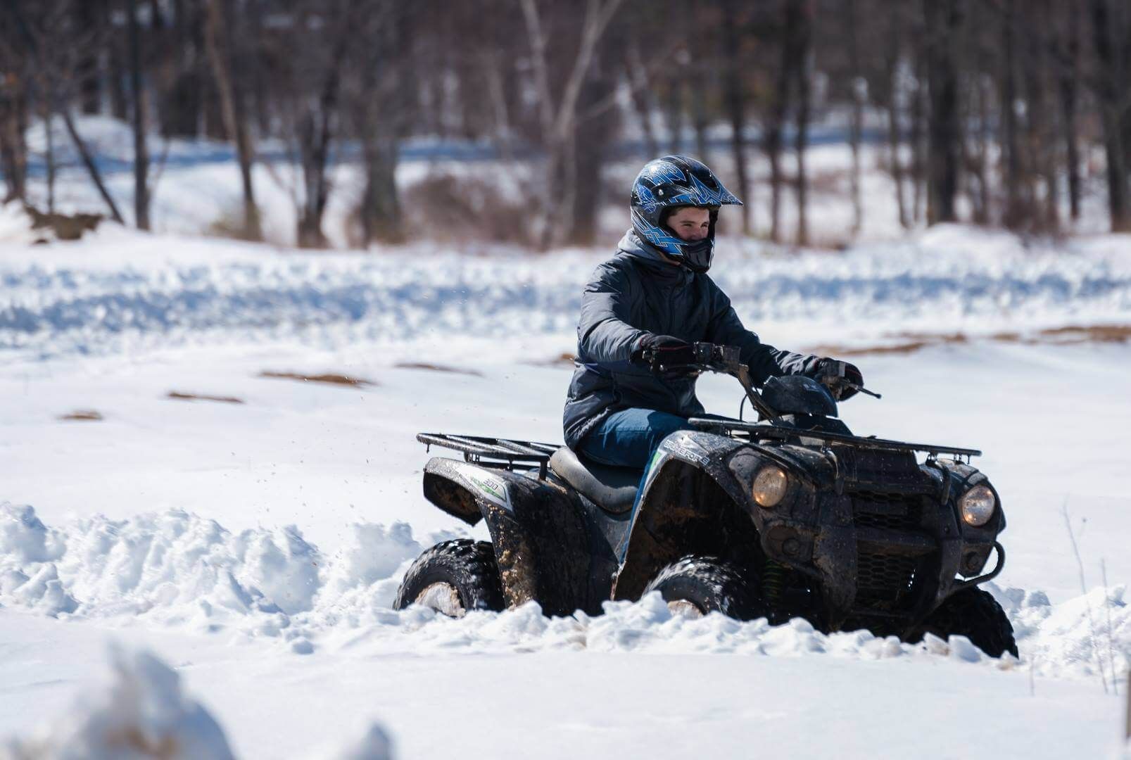 A man is riding an atv in the snow.