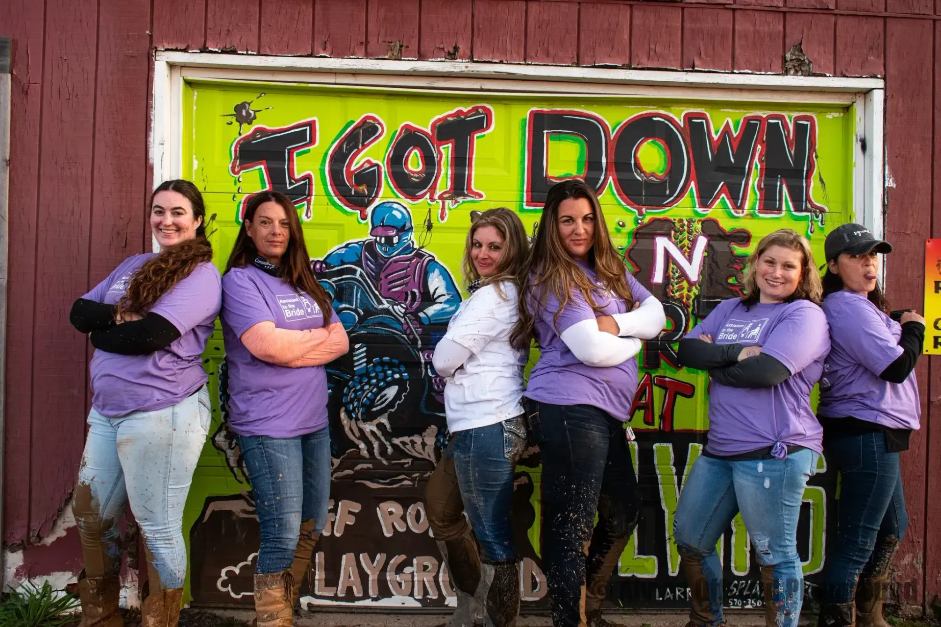 A group of women standing in front of a graffiti wall that says `` i got down ''.
