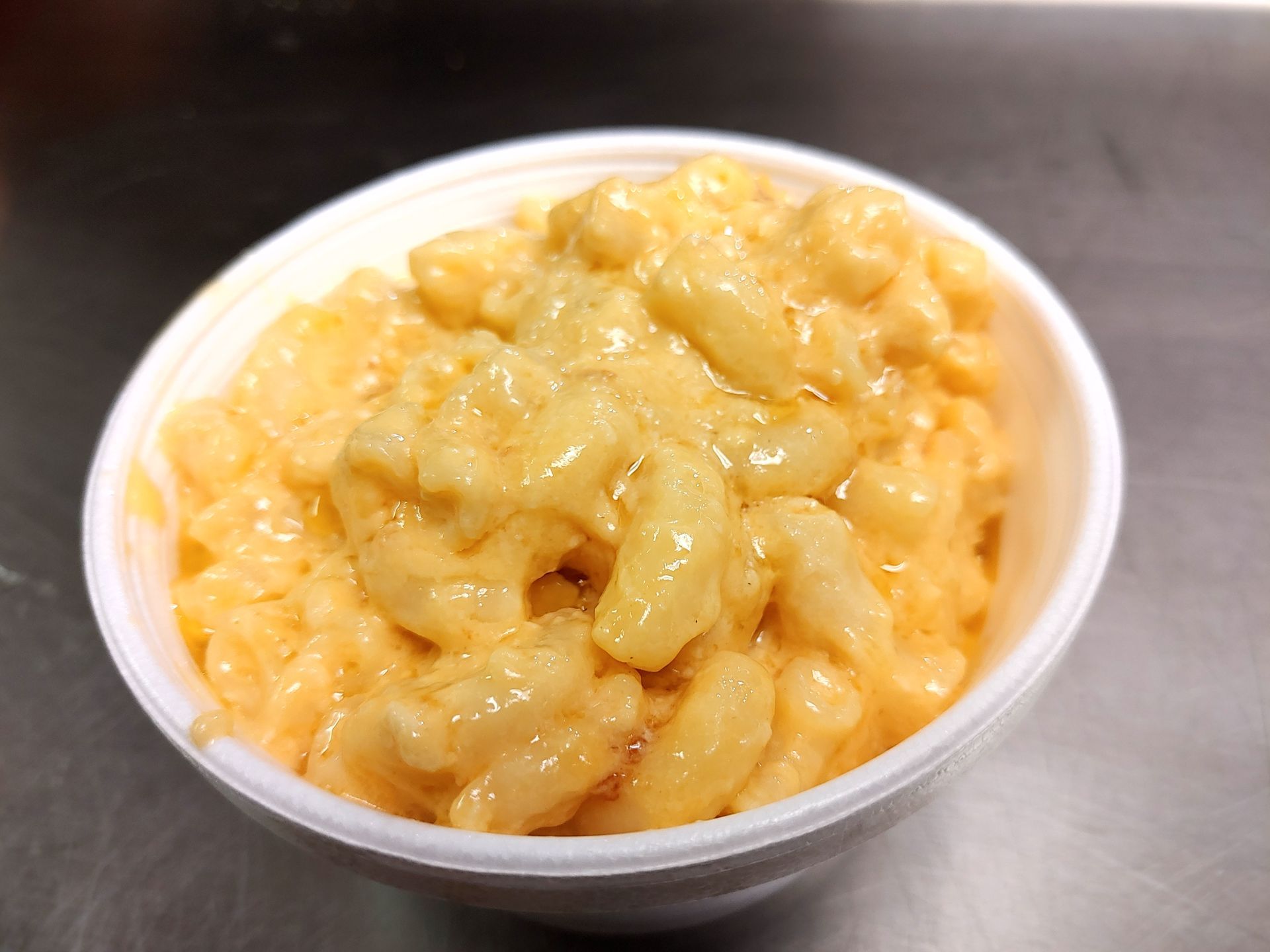 A bowl of macaroni and cheese is sitting on a table.