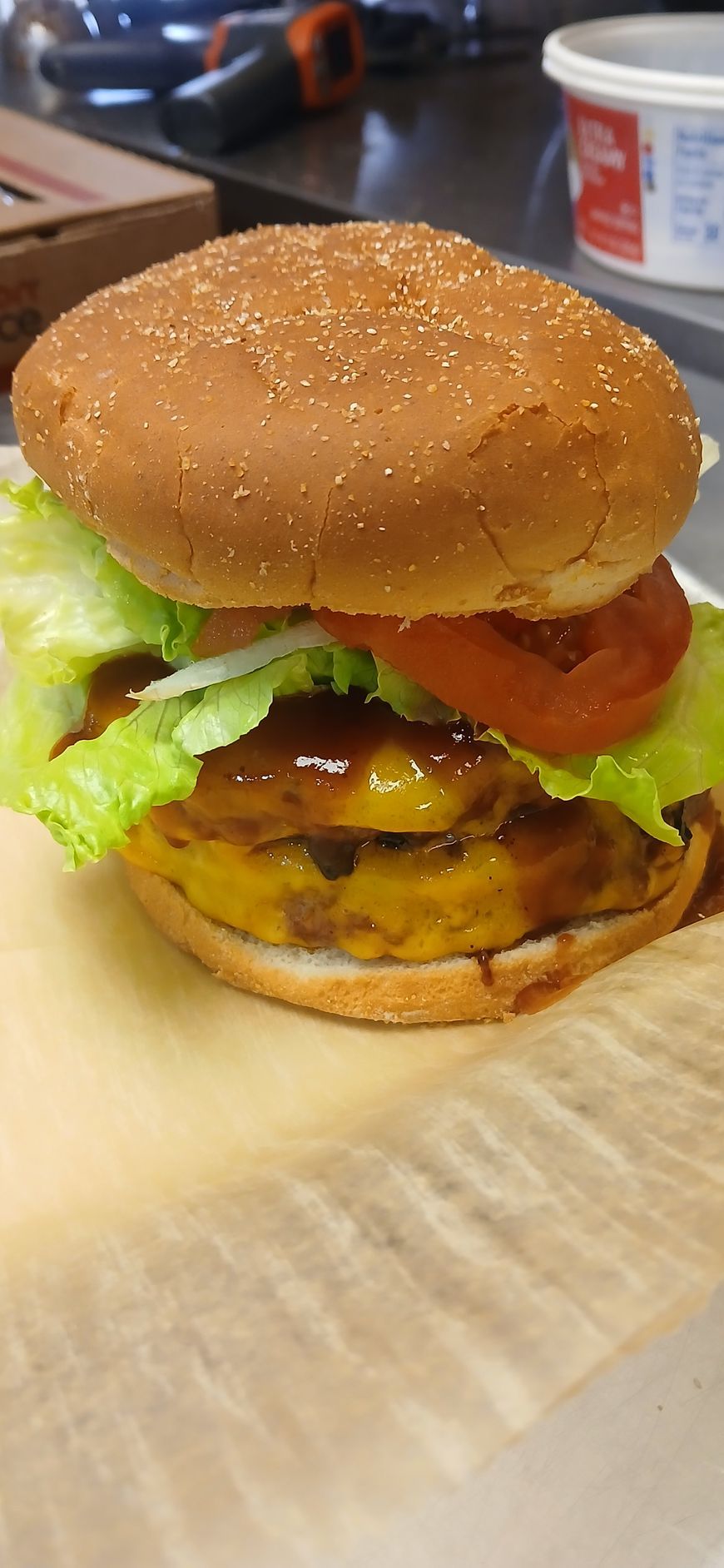A close up of a hamburger on a paper plate