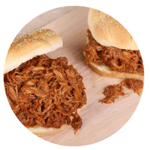 Two pulled pork sandwiches are sitting on a wooden cutting board.