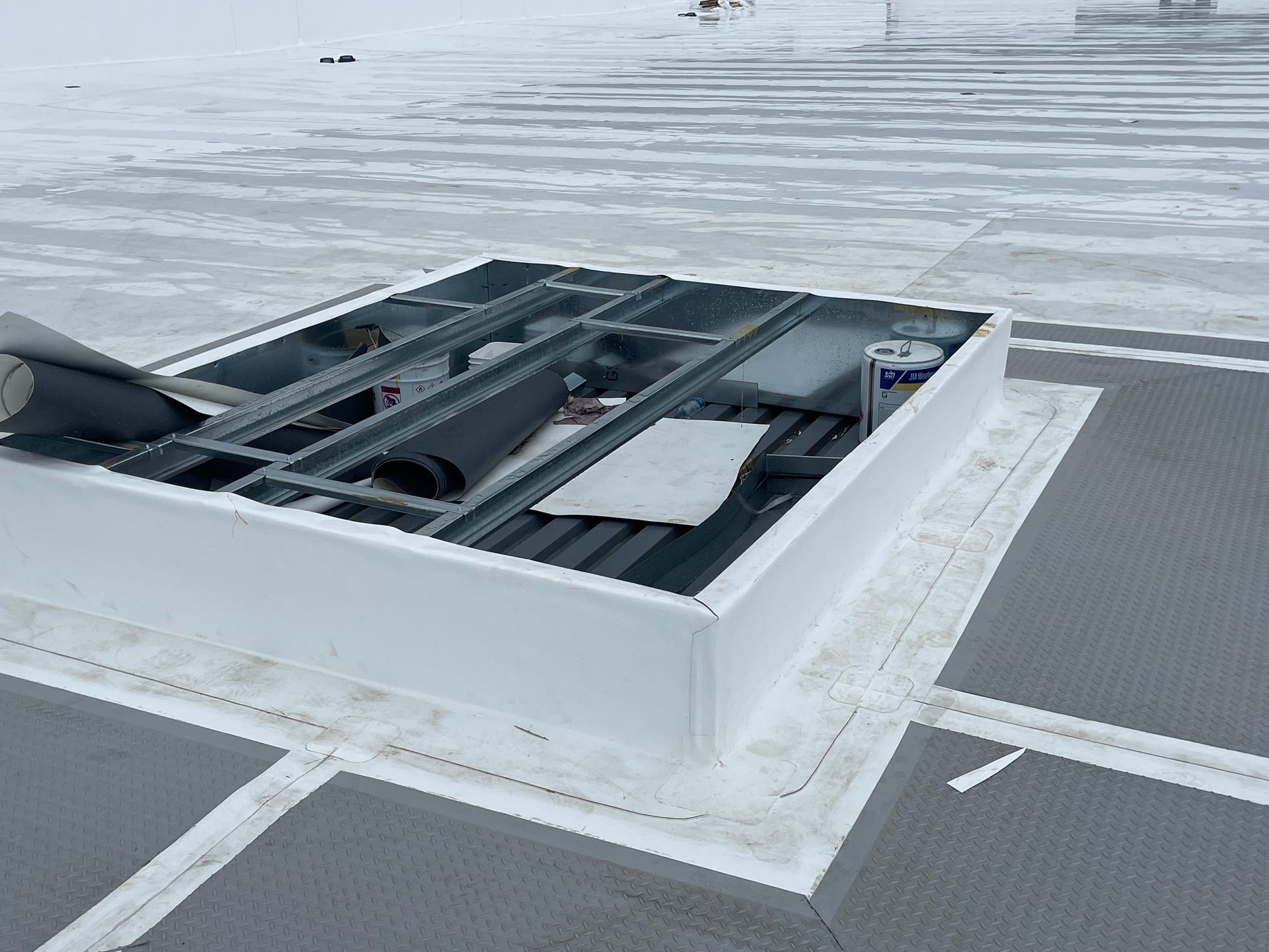 A white box is sitting on top of a snow covered roof.