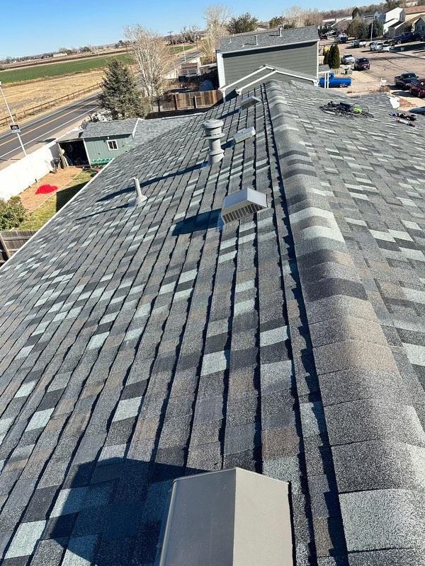 A roof with a lot of shingles and a chimney on it.
