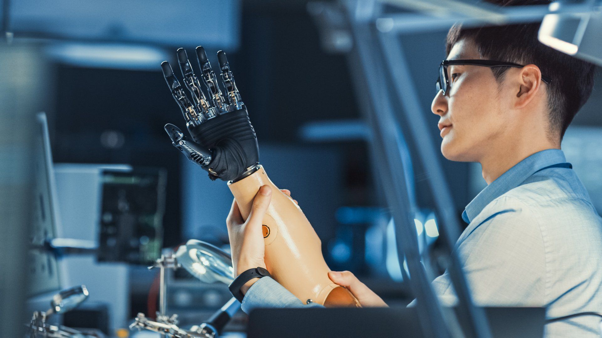 A man is working on a robotic arm in a lab.
