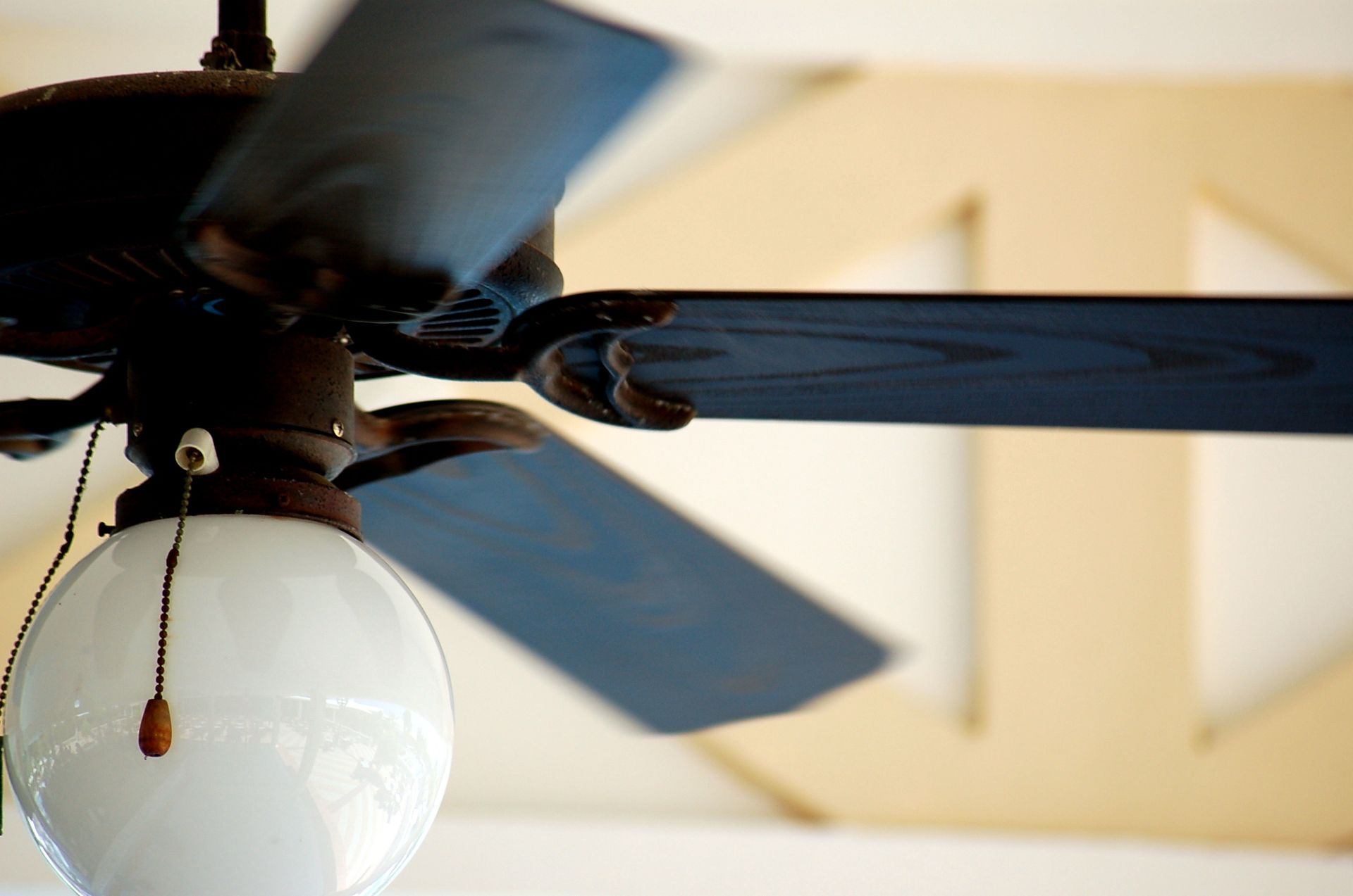 A stylish ceiling fan with an integrated light fixture installed in a cozy living room.