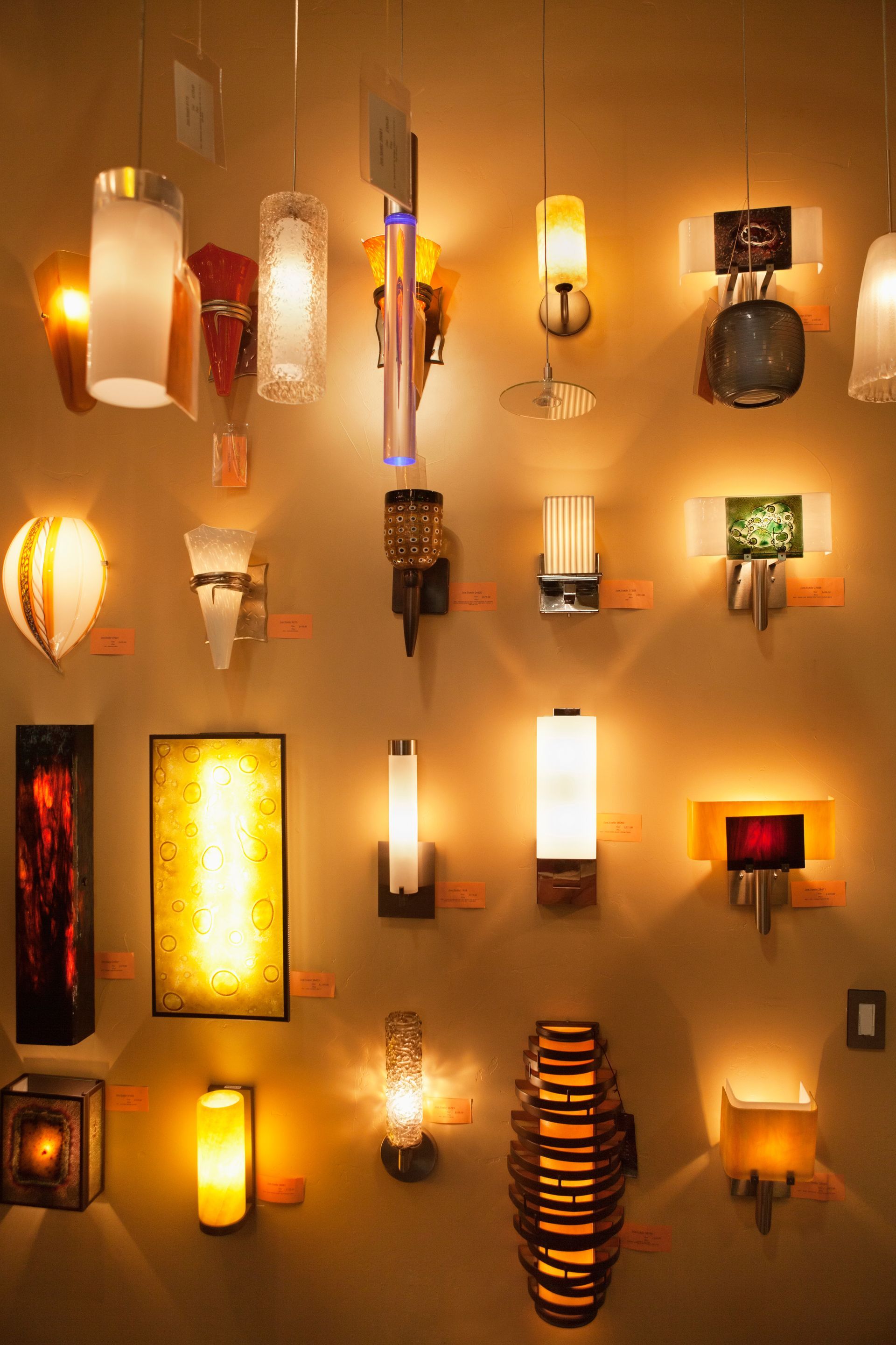 Multiple wall lamps with varying designs and finishes on display in a lights store.