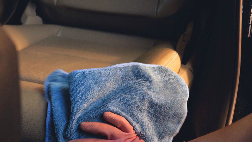 A Person Is Cleaning A Car Seat With A Towel — Shine Your Ride In Googong, NSW