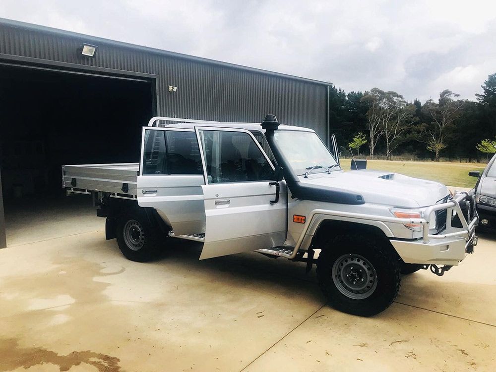 A Silver Truck With Its Doors Open is Parked in Front of a Garage — Shine Your Ride In Karabar, NSW