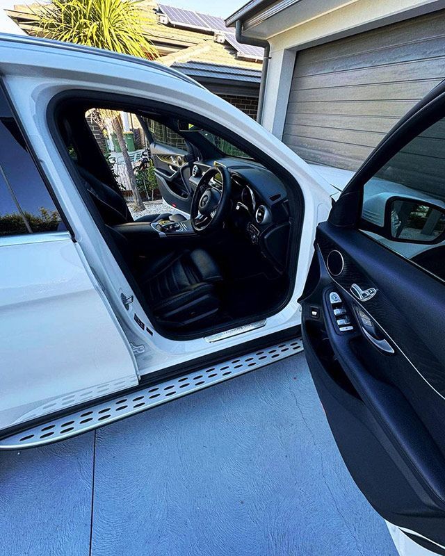A White Car is Parked in a Driveway With the Door Open — Shine Your Ride In Karabar, NSW