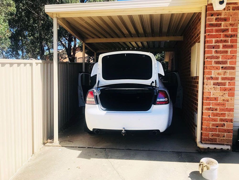 A White Car is Parked in a Carport With the Trunk Open — Shine Your Ride In Karabar, NSW