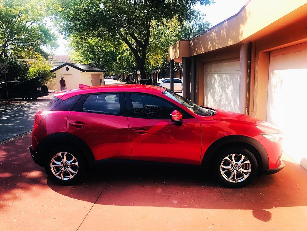 a Red Car is Parked in Front of a Garage Door — Shine Your Ride In Karabar, NSW