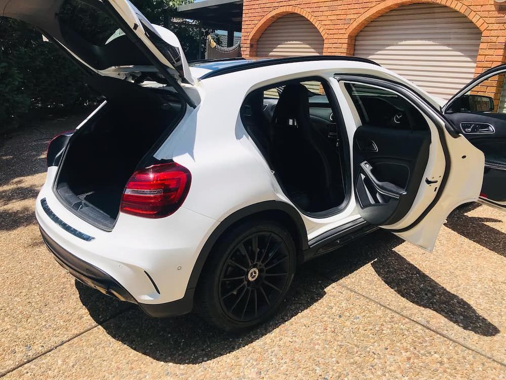 A White Car With The Trunk Open Is Parked On The Side Of The Road — Shine Your Ride In Googong, NSW
