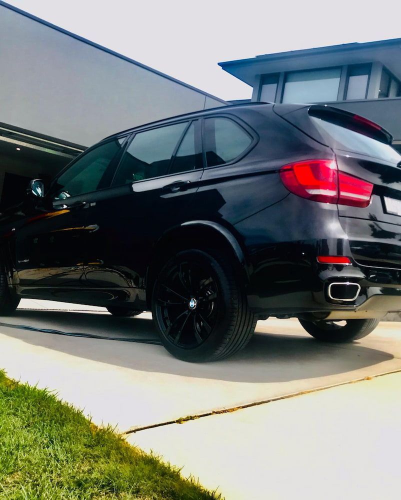 A Black Car Is Parked In Front Of A House — Shine Your Ride In Bungendore, NSW