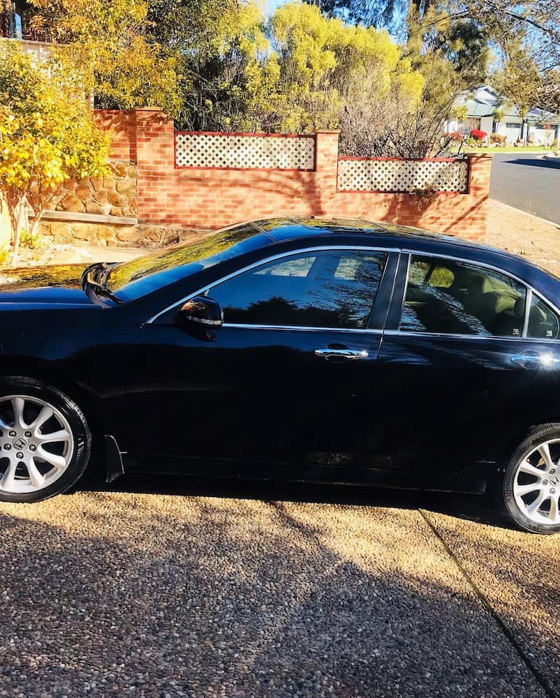 A Black Car Is Parked In A Driveway Next To A Brick Wall — Shine Your Ride In Karabar, NSW