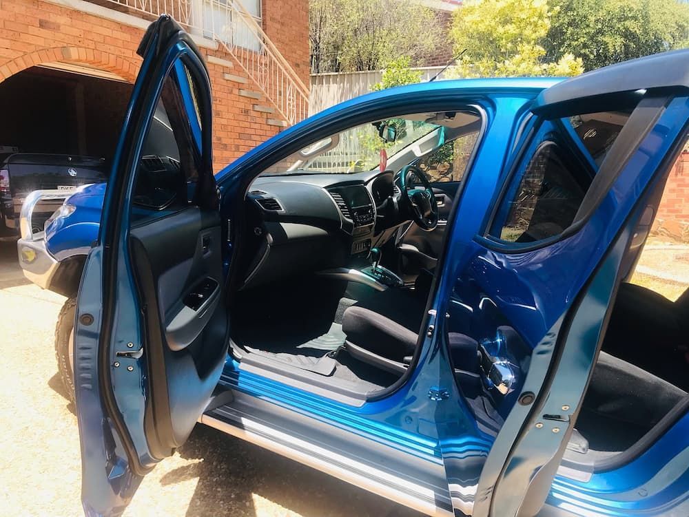 A Blue Car With Its Doors Open Is Parked In Front Of A House — Shine Your Ride In Queanbeyan, NSW