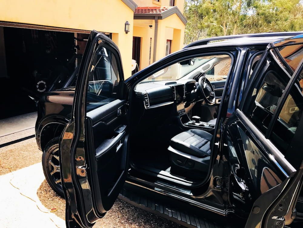 A Black Car With Its Doors Open Is Parked In Front Of A Garage — Shine Your Ride In Bungendore, NSW