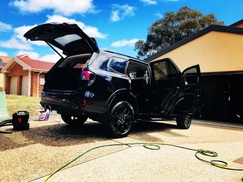 A Black Suv Is Parked In A Driveway With Its Trunk Open — Shine Your Ride In Queanbeyan, NSW