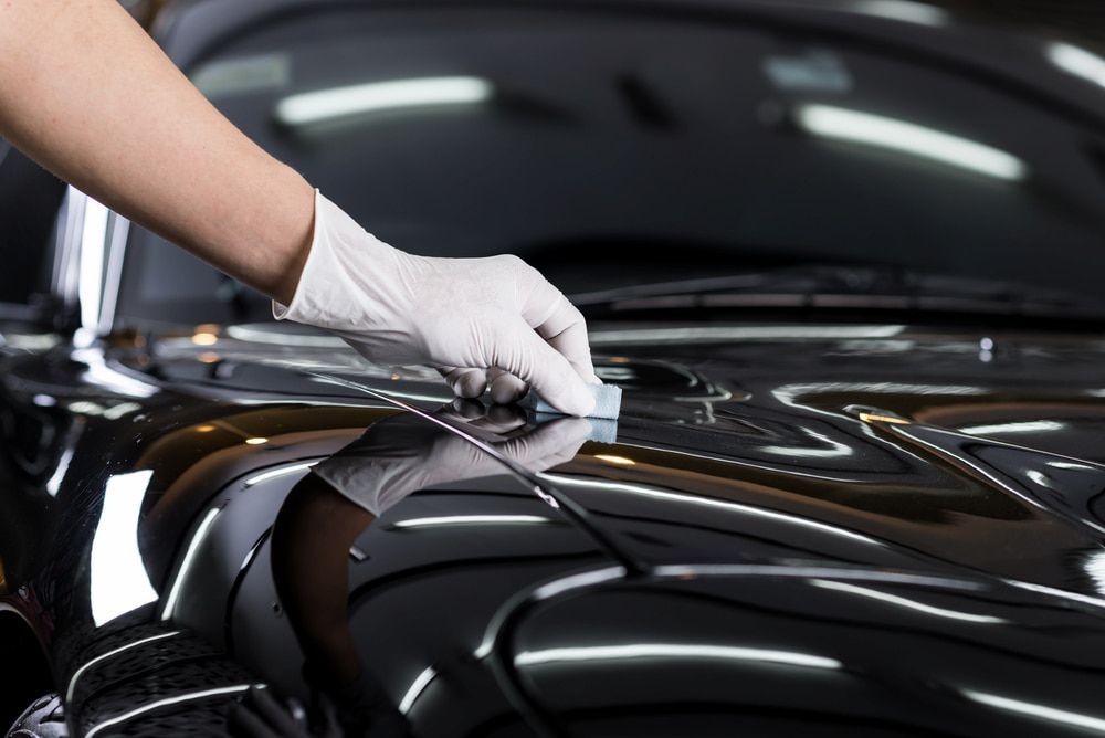 A Person Wearing White Gloves Applies Wax To A Shiny Black Car — Shine Your Ride In Queanbeyan, NSW
