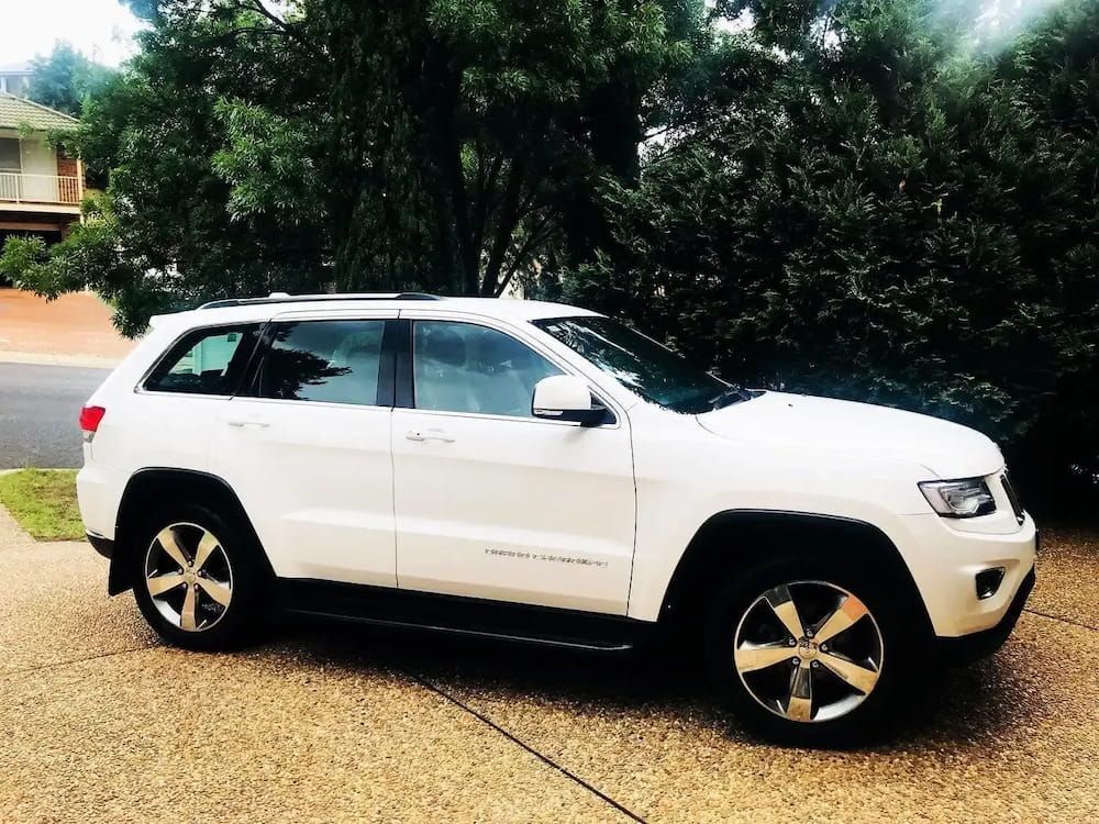 A White Jeep Stands Parked In Front Of A House — Shine Your Ride In Yass, NSW