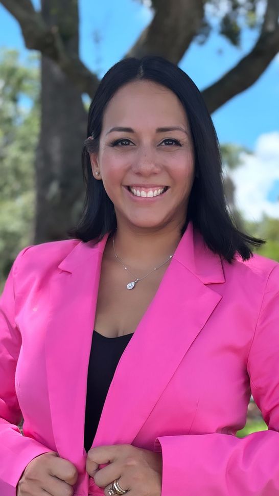 A woman is smiling looking directly to the camera.