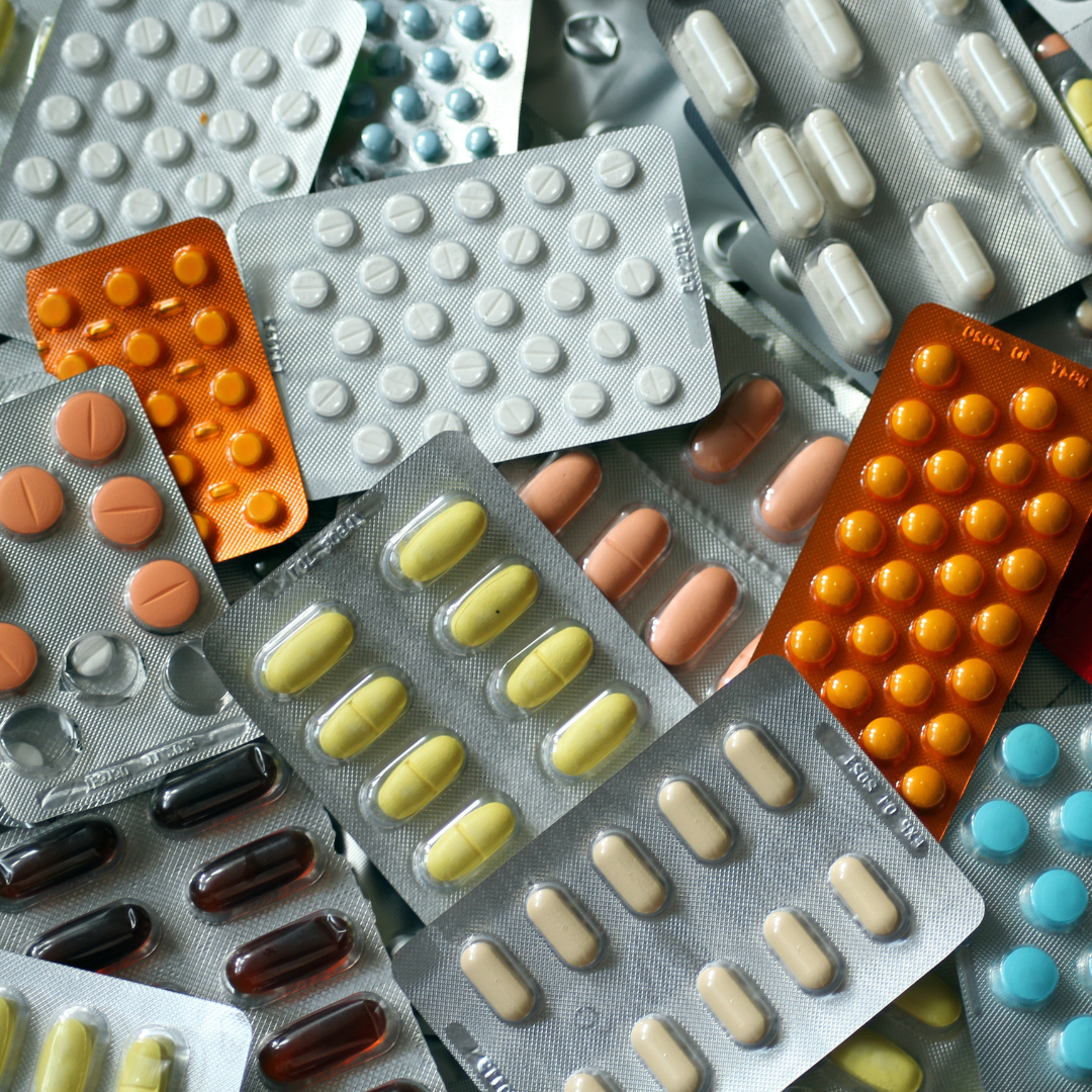 Tabletten in verschiedenfarbigen Blisterpackungen, übereinandergestapelt.
